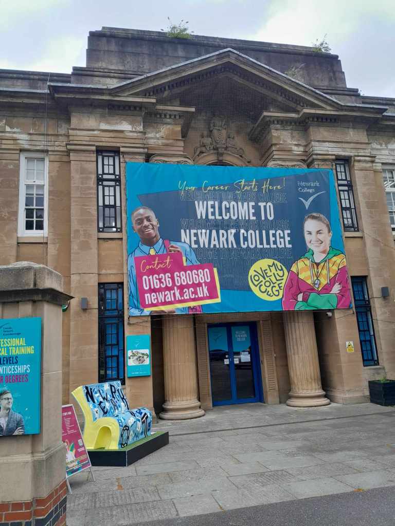 A photograph of the Alphabets bench by Charlotte Adderley outside the entrance to Newark College Reception.
